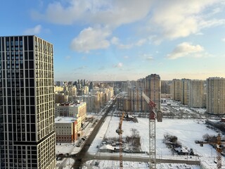 Naklejka premium A beautiful urban winter landscape showcasing a skyline alongside construction crane for building activities.