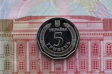Ukrainian silver coin lies on one hundred hryvnia bill. Financial and business concept. Modern...