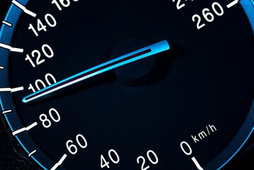Speedometer needle pointing at 100 km/h on dashboard displaying speed and distance