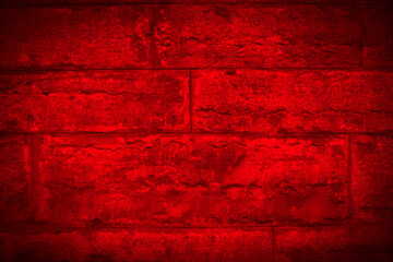 Closeup of rough ancient stonewall in dark, bright red.