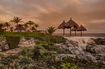 Palapas overlooking caribbean sea at sunset in puerto aventuras, mexico