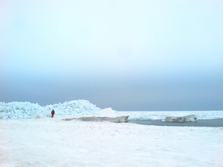 Ice floes, frozen sea, blocks of blue ice and a man in the background.