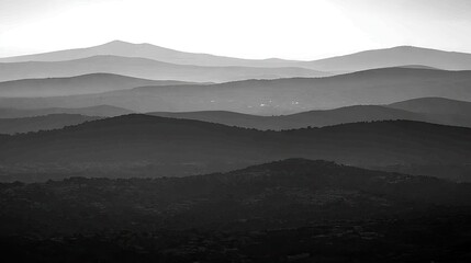 Mountain ranges at dawn, layered grayscale landscape, scenic view, possible use as stock photo.
