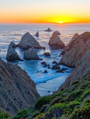 Dramatic sunset over the Pacific Ocean, showcasing rugged coastal cliffs and rocky formations at a California beach.
