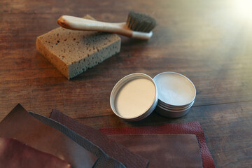 Shoe polish wax.A shoe brush on a wooden background.