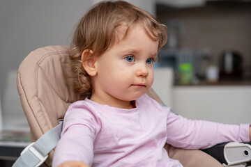 Fototapeta premium A calm and thoughtful toddler seated in a cozy home environment.