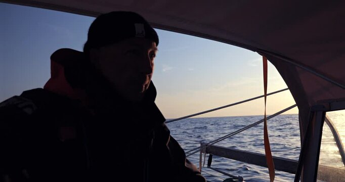 Sailor on his sailboat looking at the horizon while crossing the Bay of Biscay 
