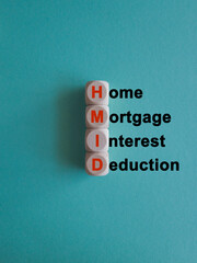 HMID Home mortgage interest deduction symbol. Wooden cubes with words Home mortgage interest deduction on beautiful blue background. Business investment concept.