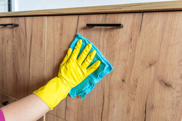 female hand wear gloves cleaning wooden furniture at house