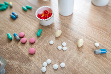 Many different pills with bottle on wooden table, health background