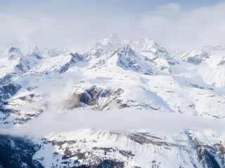 Obraz premium Winter mountain scene. High sharp rocks and snow. Cold weather and frost. View of the mountains. Photo for postcards, backgrounds, wallpapers.