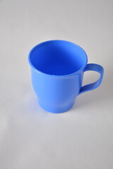 A simple blue plastic mug set against a neutral background.