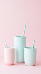 Pastel ceramic vases with pencils on pink background