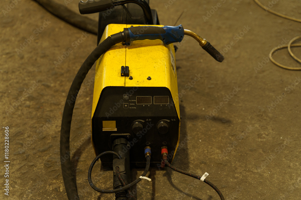 Poster Welding machine ready for use in a workshop during evening hours
