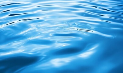 Abstract blue flowing liquid surface with metallic reflections.