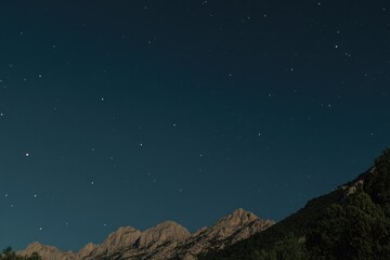 Fototapeta premium A view of a mountain under a starry night sky
