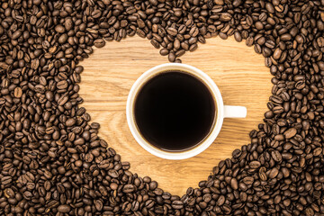 a cup of coffee surrounded by a heart of coffee beans, a round space for an inscription,, real photo, 