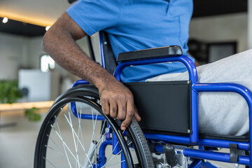 Close up of a man in blue tshirt sitting in a wheeling-chair