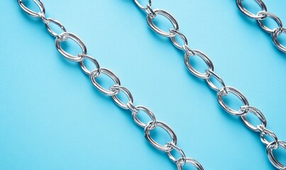 Fototapeta premium Close up of intricate metal chain on blue background, symbolizing connection