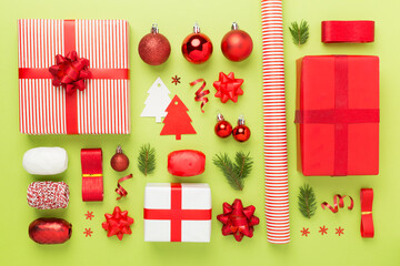 Handmade wrapped christmas gift boxes with stuff on color background, top view