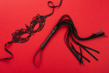 Black whip on color background, top view. BDSM concept