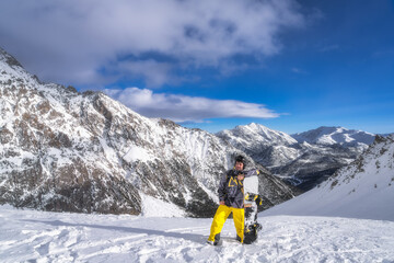 A snowboarder confidently poses on a stunning snowy mountain landscape, capturing the thrill of winter sports as well as the picturesque scenery that surrounds him, Montgenevre, Alps, France