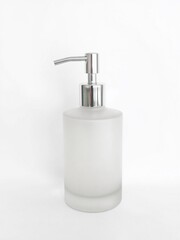 Obraz premium A single frosted glass pump dispenser with a metallic silver pump, set on a clean white background