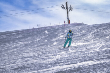 A skilled skier gracefully glides down a snowy slope, enjoying the thrill of winter sports, all...