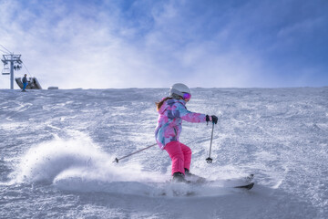 A skilled skier gracefully glides down a snowy slope in colorful attire, standing out against the...
