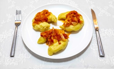 Classic Ukrainian food, perohê or veréneki stuffed with potatoes and cottage cheese and cooked, served with different types of sauce and salted and sour cream