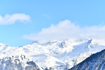 Fototapeta premium French alps on a sunny day under the clouds by winter covered with snow