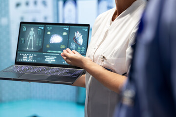 Medical staff analyzing heart x ray scan test results to discuss treatment plan for disease prevention. Group of licensed experts examining cardiovascular issues on a ecg radiography. Close up.