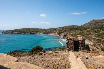 Landscape of the coast of the island of Sant'Antioco with the turquoise sea and the red cliffs on a...