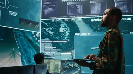 Team of military specialists operate in a secret service command post, managing surveillance...