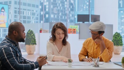 Entrepreneur and real estate agent evaluate investment opportunities by studying blueprints, planning a new high class office layout. Business people meeting realtor financier. Camera B.