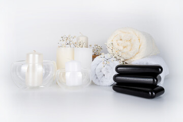 A serene spa arrangement featuring soft towels, elegant candles, and decorative stones, creating a calming ambiance for relaxation and self-care.