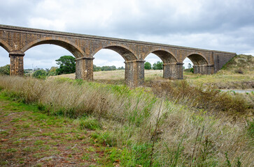 The historic Malmsbury Railway Viaduct, a large brick and stone masonry arch bridge over the Coliban River in regional Victoria, Australia.