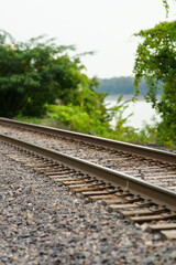 Obraz premium railroad tracks along the river with tree