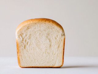 A Halved Loaf of Bread on a Clean White Surface, Highlighting Its Soft Interior and Crusty Exterior Texture
