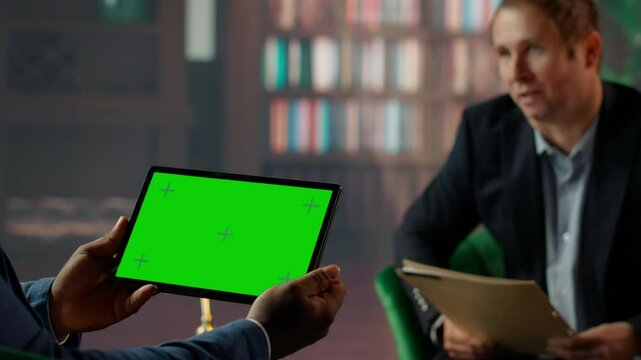 Team of skilled agents engaging in a strategic meeting with chroma key screen, emphasizing professionalism and discretion in a government mission. CIA staff gathering data. Camera B.