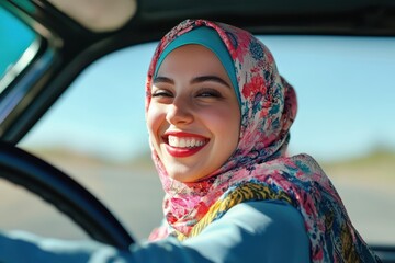 Joyful young Muslim woman in hijab driving