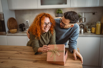 happy delight couple boyfriend and girlfriend open gift together