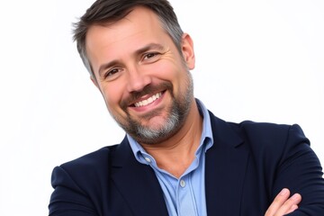 a portrait of a middle-aged man with a beard and mustache. He is standing with his arms crossed in front of him and is smiling at the camera.