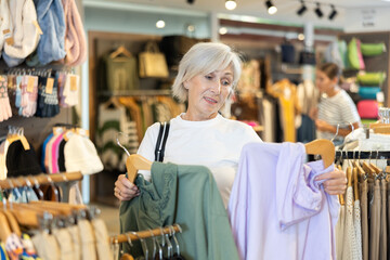 Woman flips through racks of hoodies, searching for perfect one to add to her collection.