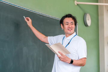 黒板の前で授業をする男性教師
