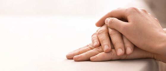 Young woman holding hands of grandmother at table