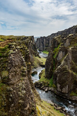 A river flows gracefully through a scenic canyon in the south of Iceland