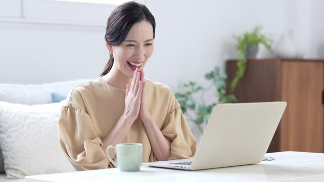 パソコンを使う喜んだ表情の女性