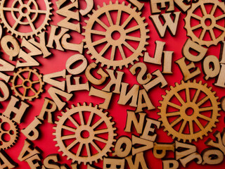 Closeup wooden word and wooden gear on a red background
