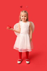 Cute little girl dressed as cupid with gift box on red background. Valentine's Day celebration